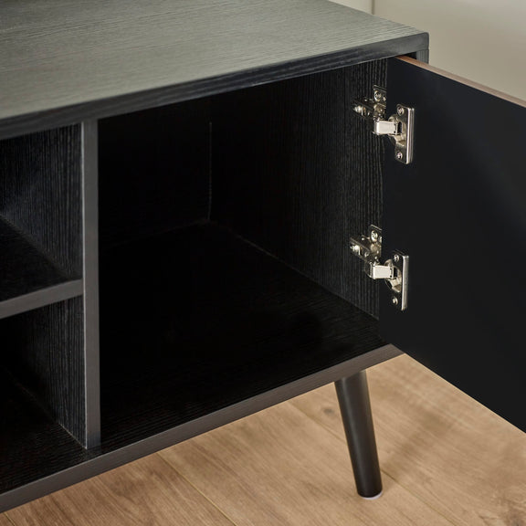 Close-up of a black cabinet with open door on a wooden floor