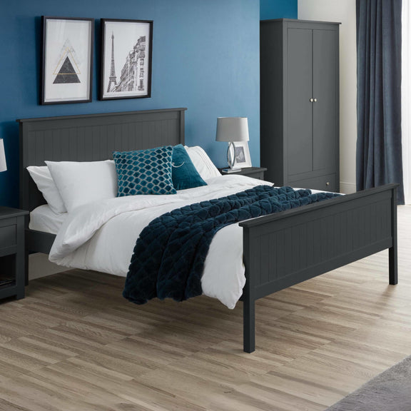 Bedroom with dark gray bed frame, white bedding, and blue accents against a blue wall.