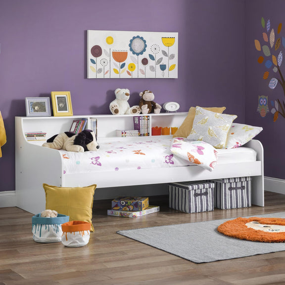 Children's bedroom with a bed, toys, and decorative elements on a purple wall.