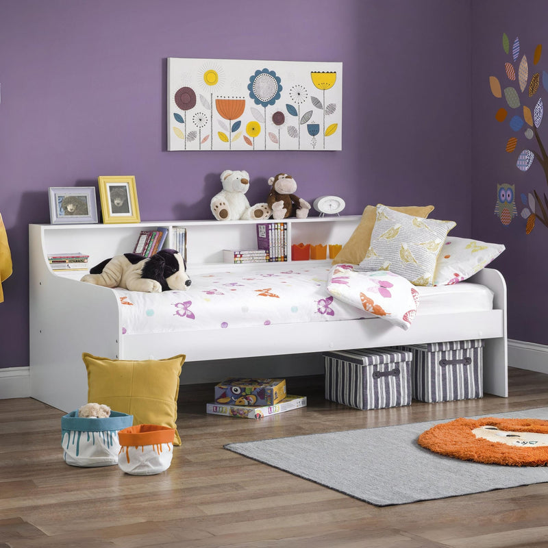 Children's bedroom with a bed, toys, and decorative elements on a purple wall.