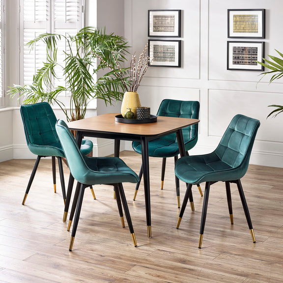 Dining room with a wooden table and teal chairs on a wooden floor.