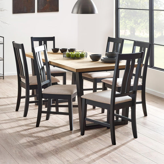 Dining room with a wooden table and black chairs with beige cushions.