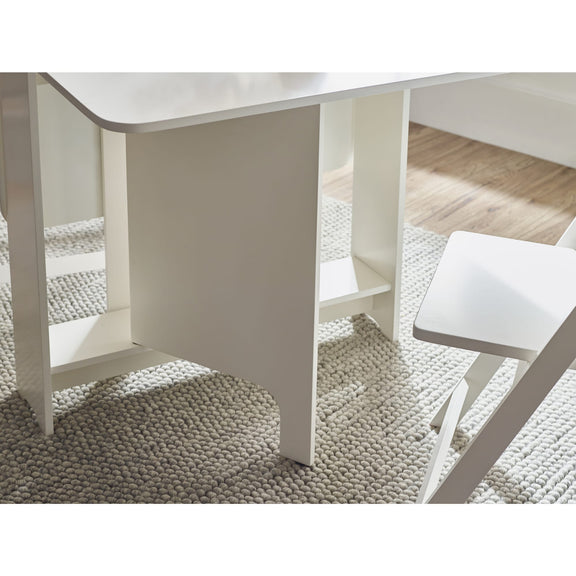 White dining table and chairs on a textured rug