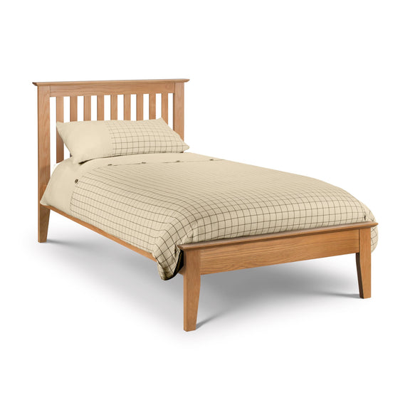 Wooden bed with beige bedding on a white background