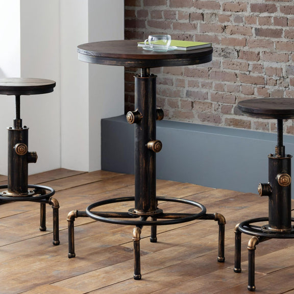 Three industrial-style tables with metal legs on a wooden floor against a brick wall.