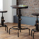 Three industrial-style tables with metal legs on a wooden floor against a brick wall.