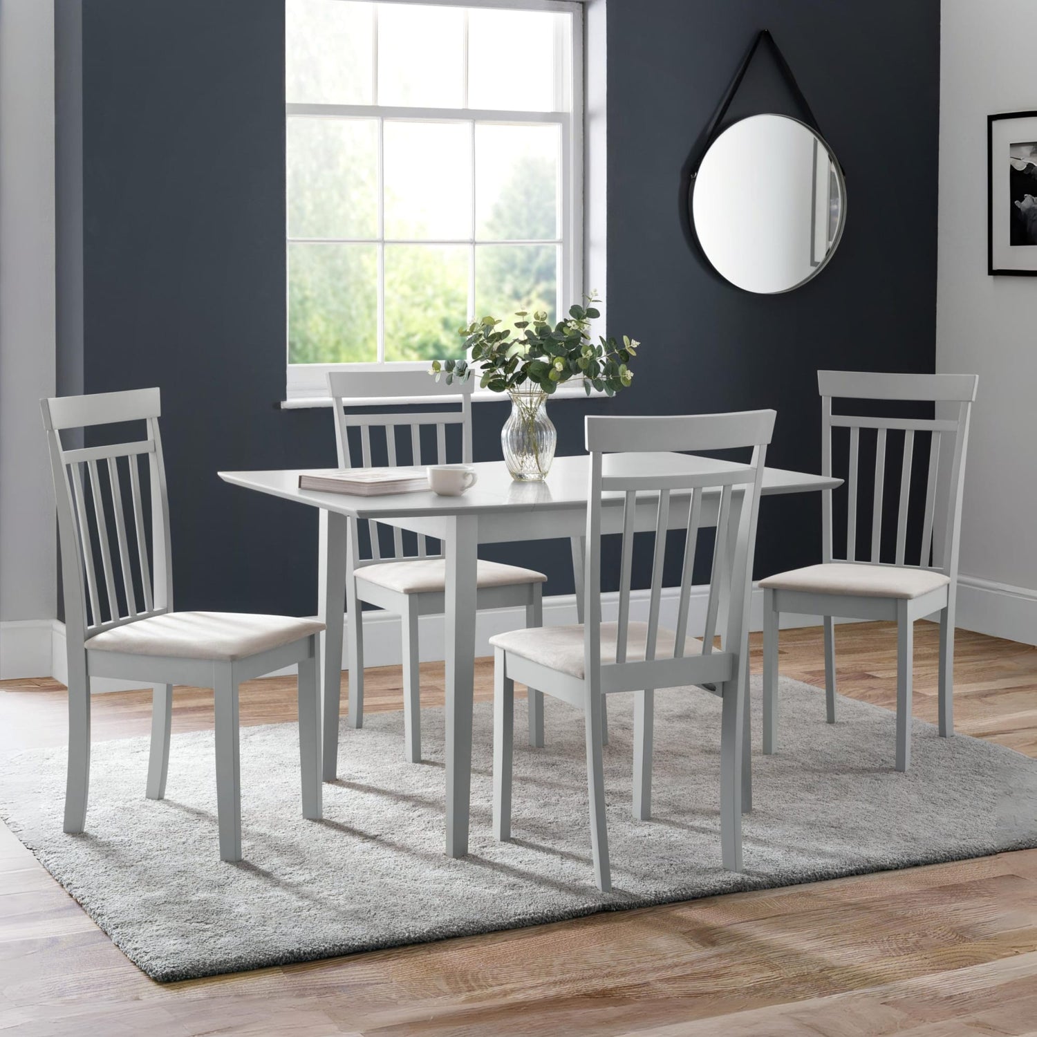 Dining room with a table and chairs in a room with a window and mirror.