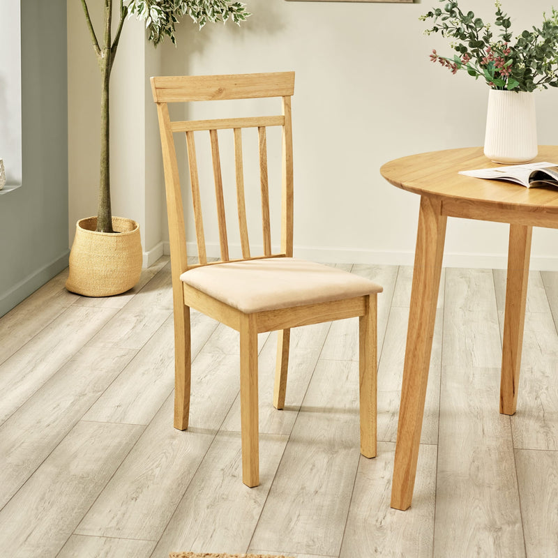 Wooden chair and table set in a room with plants and books.