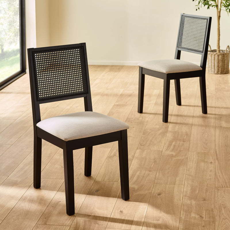 Two wooden chairs with woven backrests on a wooden floor.