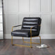 Black leather armchair with gold frame on a wooden floor against a gray wall.