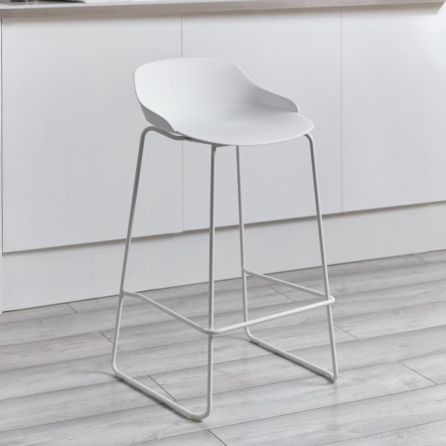 White bar stool on a wooden floor with a neutral background