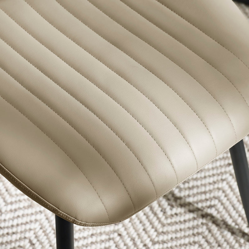 Close-up of a beige quilted chair seat on a textured surface