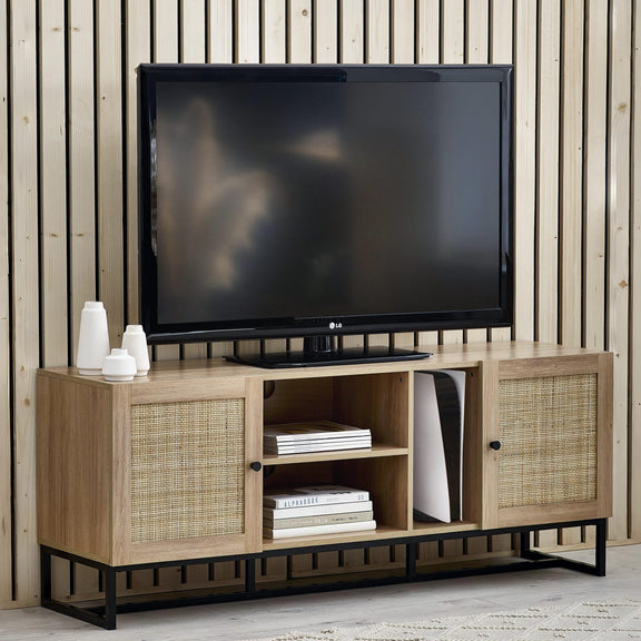Wooden TV stand with a television on top against a wooden paneled wall.
