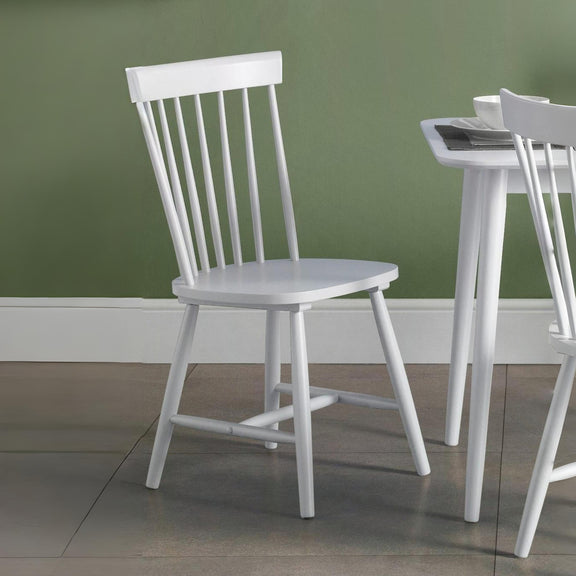 White wooden chair against a green wall
