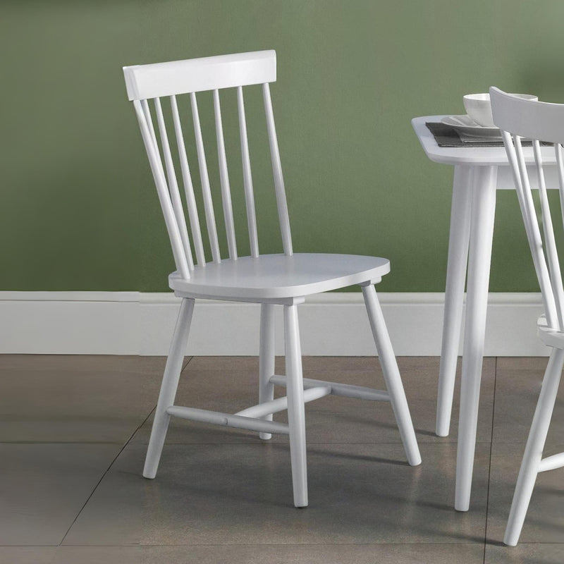 White wooden chair against a green wall