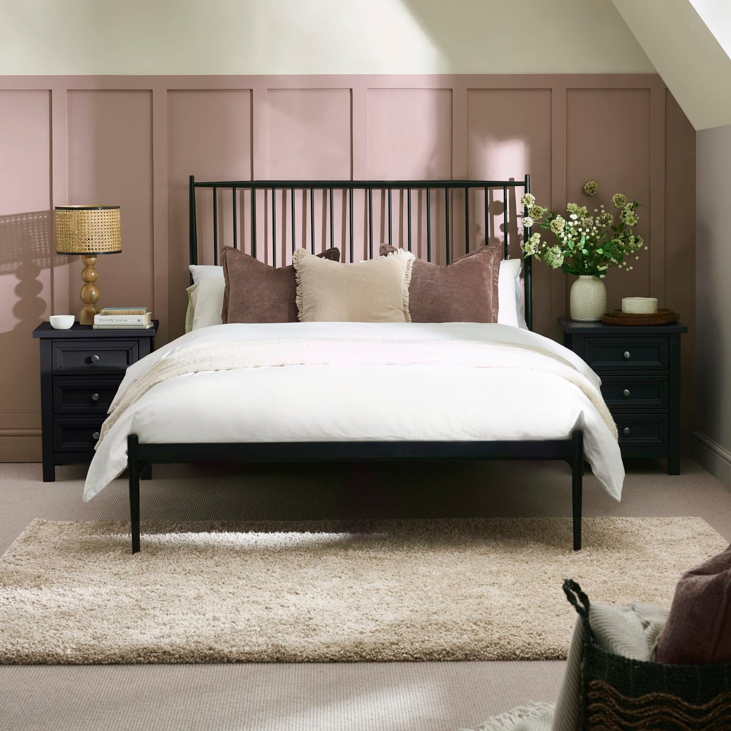 Bedroom with a black metal bed frame, white bedding, and decorative pillows.