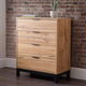 Wooden dresser with four drawers against a brick wall.