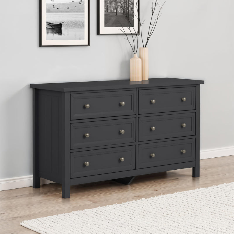 Black dresser with six drawers in a room with light gray walls and a white rug.