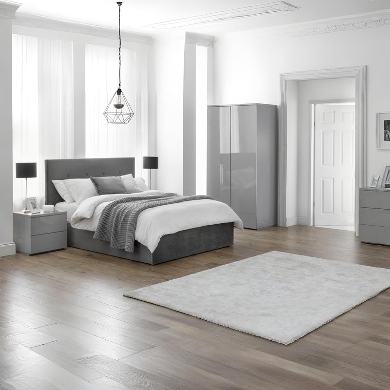 Modern bedroom with gray bed, nightstands, and wardrobe.