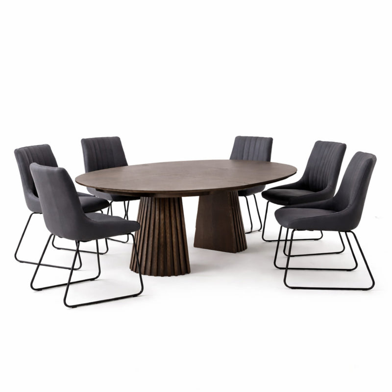 Round wooden dining table with six dark gray chairs on a white background