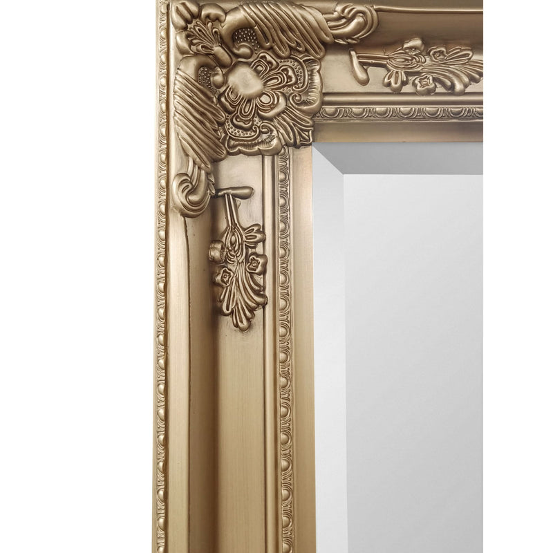 Decorative gold mirror with intricate detailing on a white background