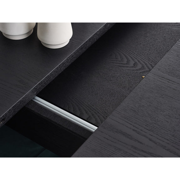 Close-up of a dark wooden surface with a drawer partially open, showing a metallic handle.