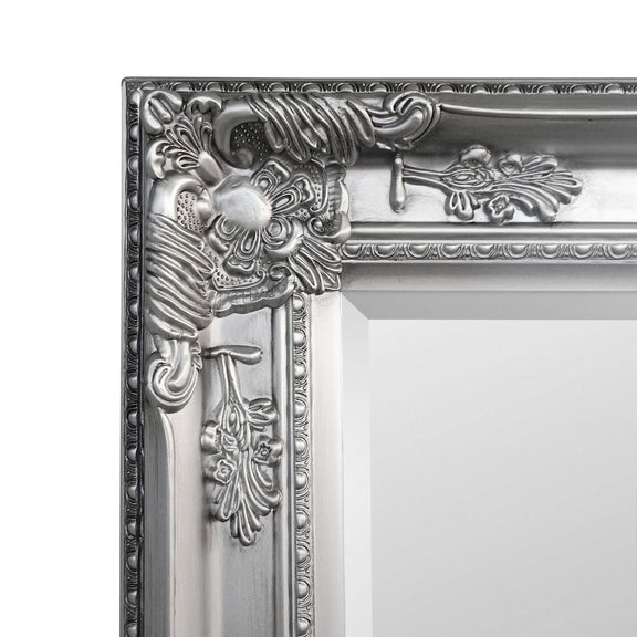 Decorative silver mirror frame with intricate designs on a white background