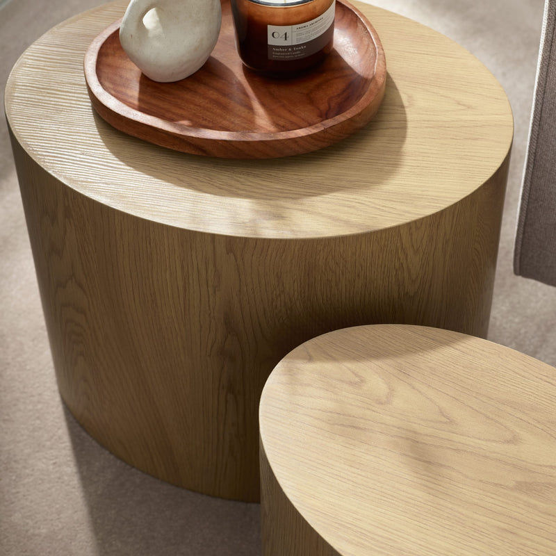 Wooden side table with a wooden tray holding decorative items on a neutral background