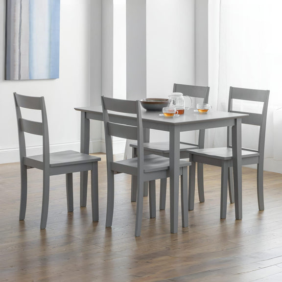 Gray dining table with four matching chairs in a room with light-colored walls and wooden flooring.