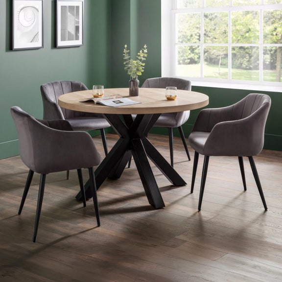 Dining room with round wooden table and four gray chairs in a well-lit room.