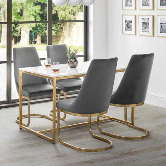 Dining room with a table and four gray chairs with gold legs.