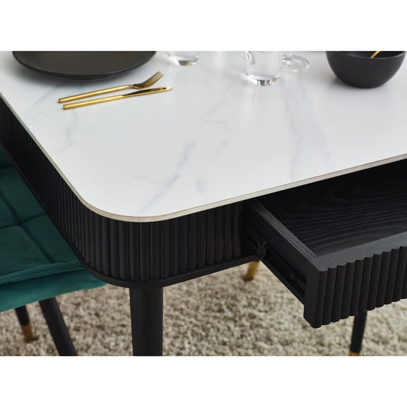 Dining table with marble-like surface and black frame, set for a meal.