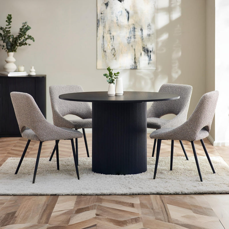 Dining room with a black round table and gray chairs on a wooden floor.