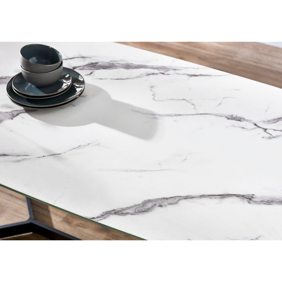 Marble-patterned tablecloth on a wooden table with black and white dishes.