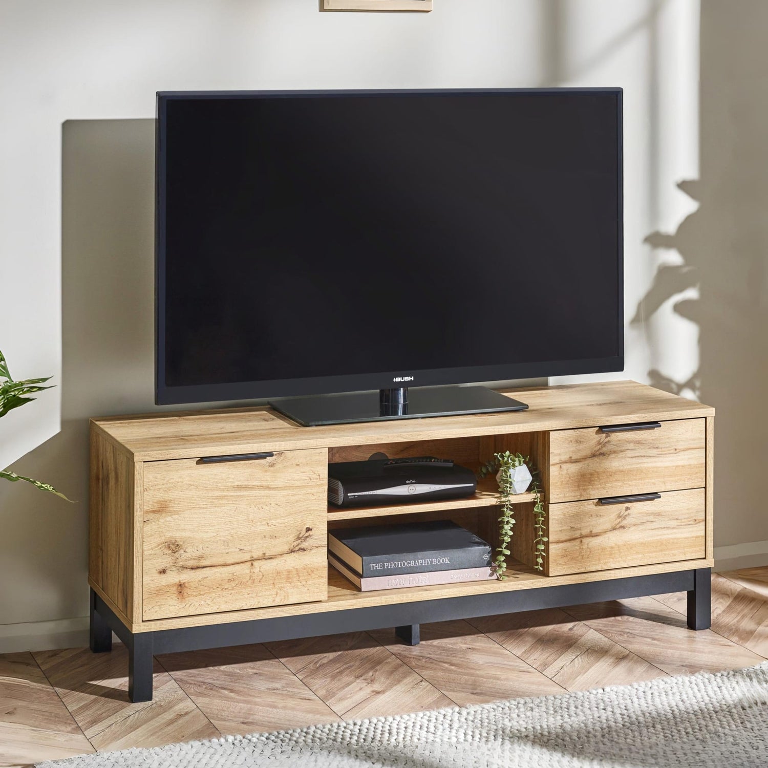 Wooden TV stand with a television on top in a room setting.