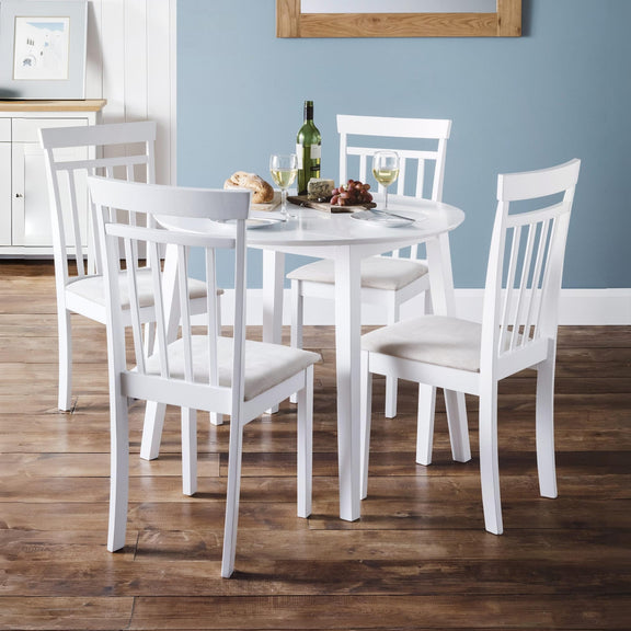 White dining table set with chairs in a room with blue walls.