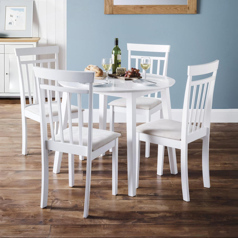 White dining table set with chairs in a room with blue walls.