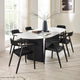 Modern dining room with a white oval table and black chairs.