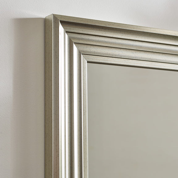 Silver framed mirror on a white wall