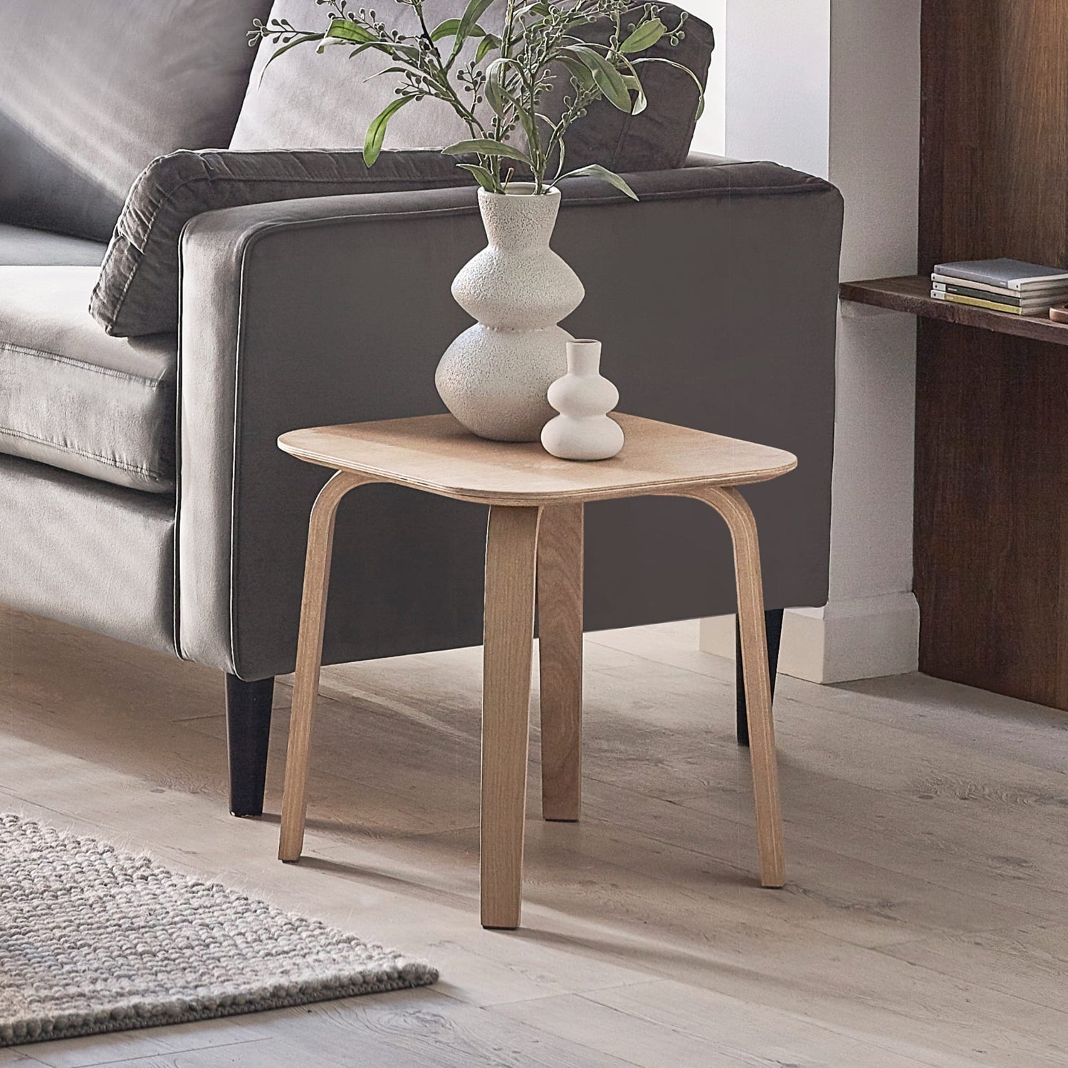 Wooden side table with decorative vases in a living room setting