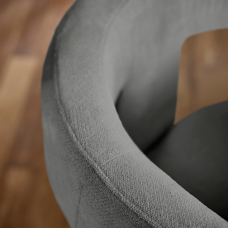 Close-up of a textured gray chair armrest with a blurred background