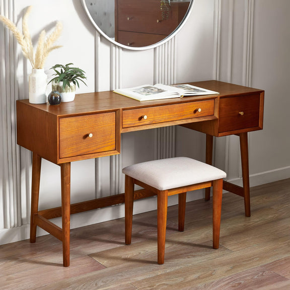 Wooden vanity desk with mirror, stool, and decorative items in a room.
