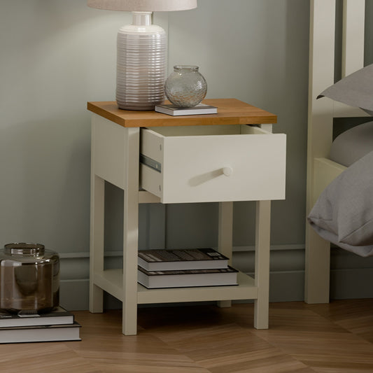 White nightstand with wooden top in a bedroom setting