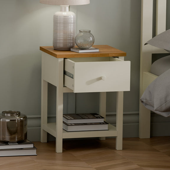 White nightstand with wooden top in a bedroom setting