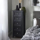 Black tall dresser with decorative items in a bedroom setting