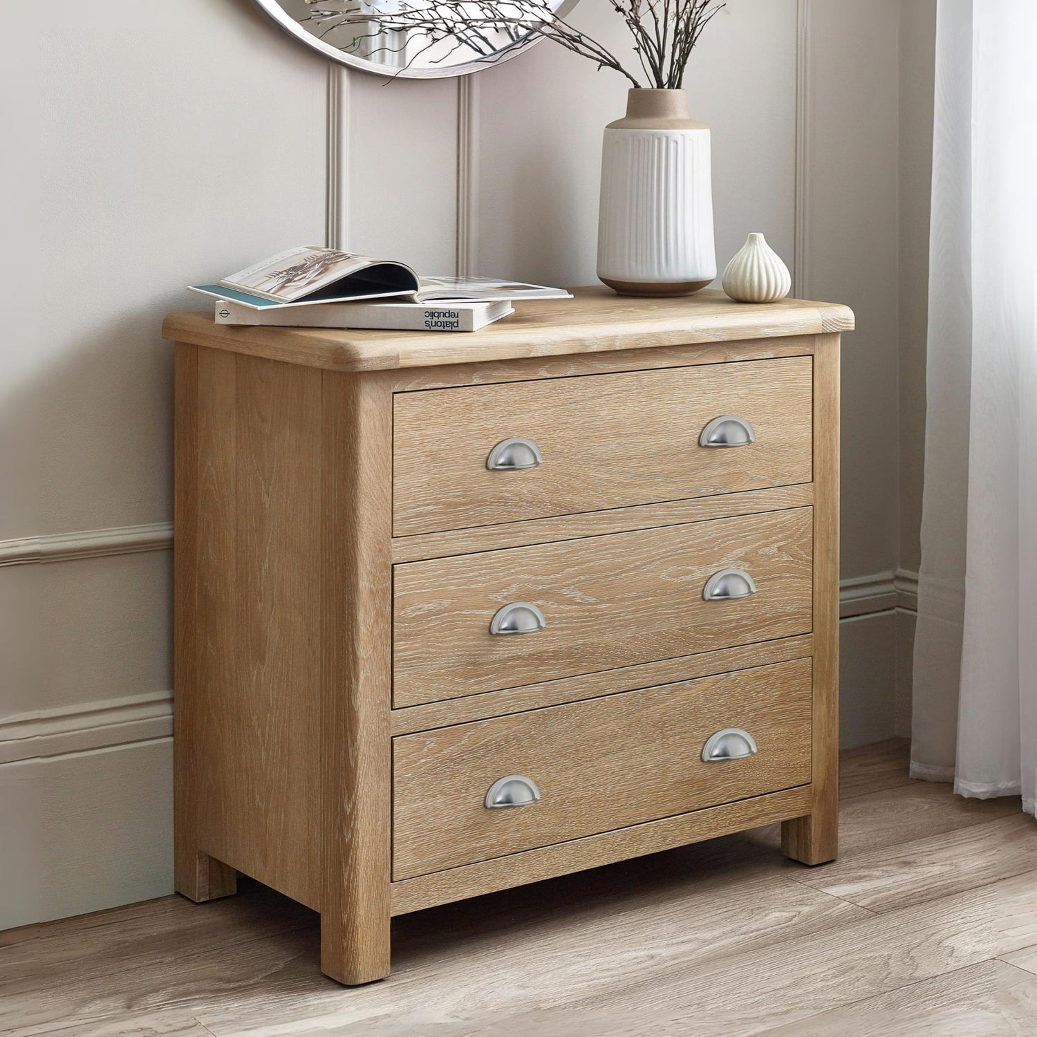 Wooden dresser with three drawers in a room setting.