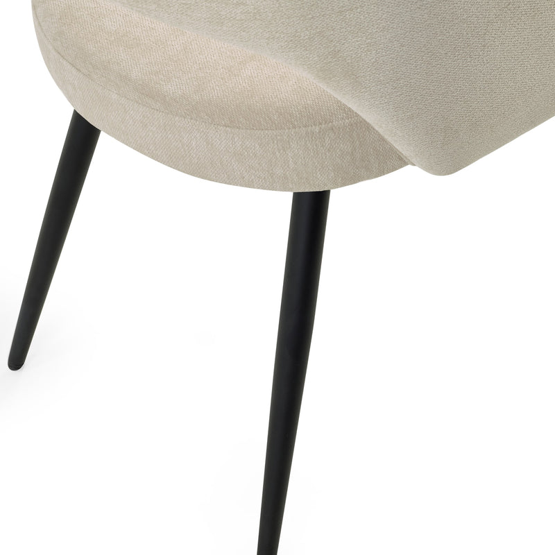 Close-up of a beige upholstered chair with black legs on a white background