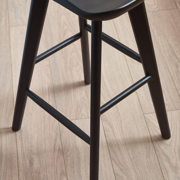 Black bar stool on a wooden floor