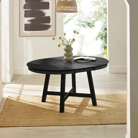 Black round coffee table with a vase and book in a bright room.