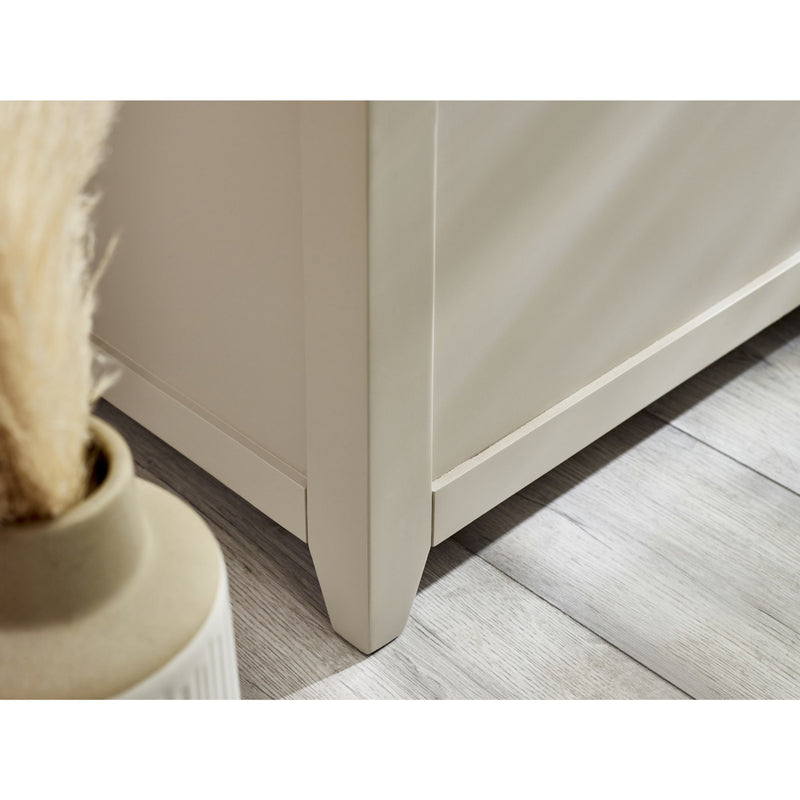 Close-up of a beige cabinet corner with a decorative vase on a wooden floor.